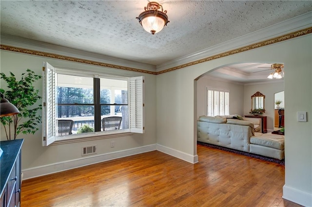 interior space featuring ornamental molding, hardwood / wood-style floors, ceiling fan, and a textured ceiling