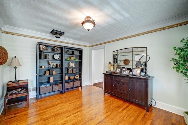 interior space with ornamental molding, a textured ceiling, and light hardwood / wood-style flooring