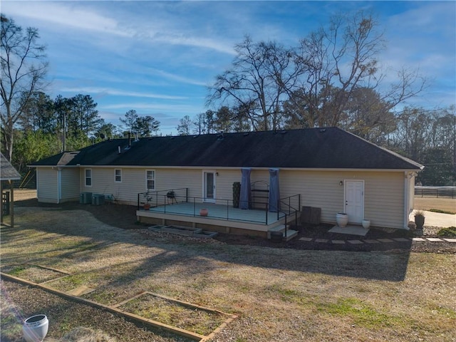 back of house featuring a deck and a lawn