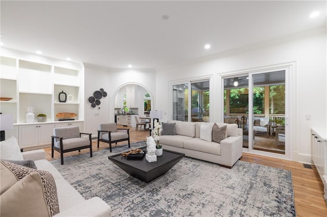 510 Northland Ridge Ct, Sandy Springs, GA 30342 - living room featuring crown molding, healthy amount of natural light, arched walkways, light wood-style floors, and built in features