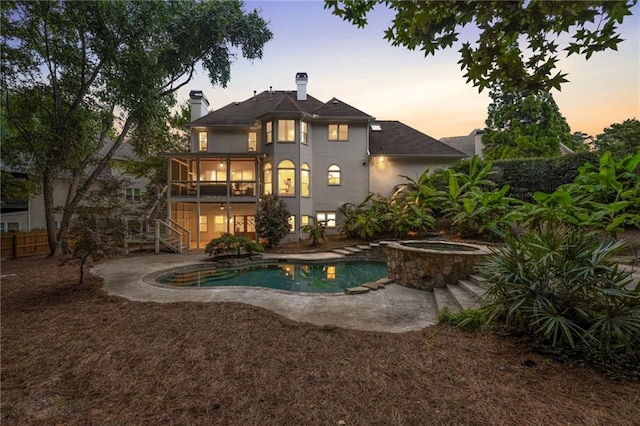 510 Northland Ridge Ct, Sandy Springs, GA 30342 - back of property at dusk with stairs, an in-ground hot tub, a chimney, an outdoor pool, and a patio area