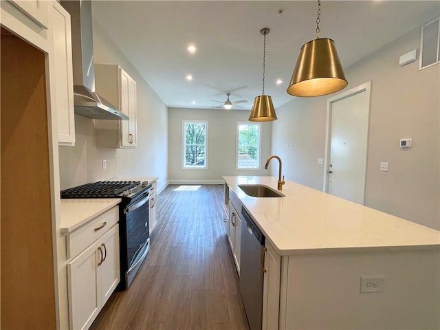 kitchen featuring sink, wall chimney range hood, an island with sink, pendant lighting, and appliances with stainless steel finishes