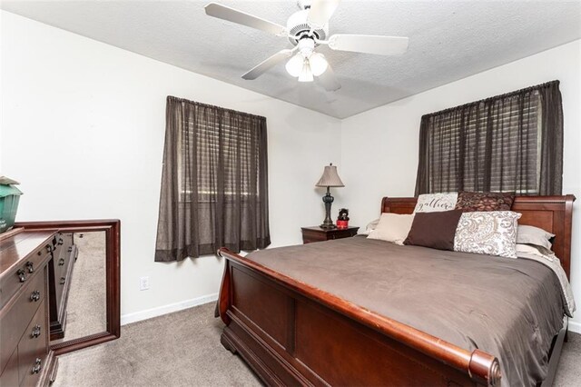 bedroom with carpet floors, a textured ceiling, and ceiling fan