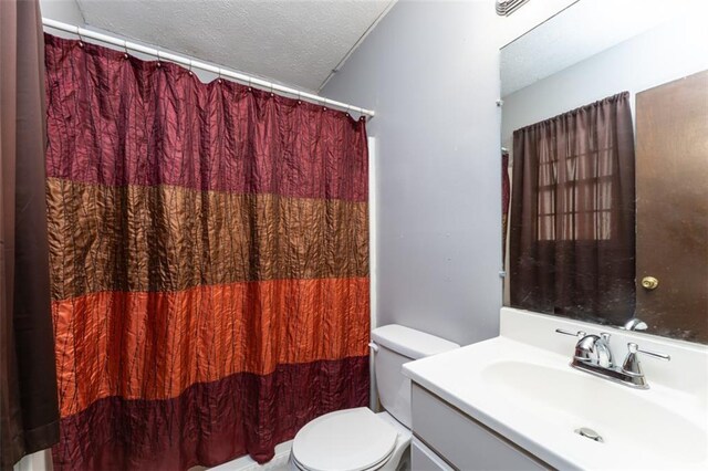 bathroom featuring vanity, a textured ceiling, and toilet