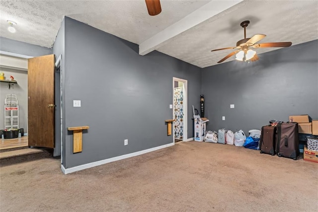 interior space featuring a textured ceiling, carpet flooring, beam ceiling, and ceiling fan