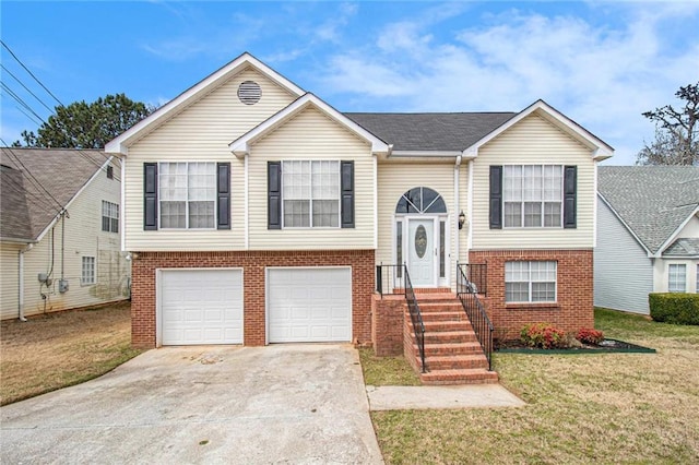 bi-level home featuring a front lawn, brick siding, an attached garage, and driveway