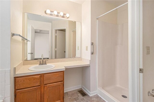 full bathroom featuring visible vents, baseboards, a stall shower, and vanity