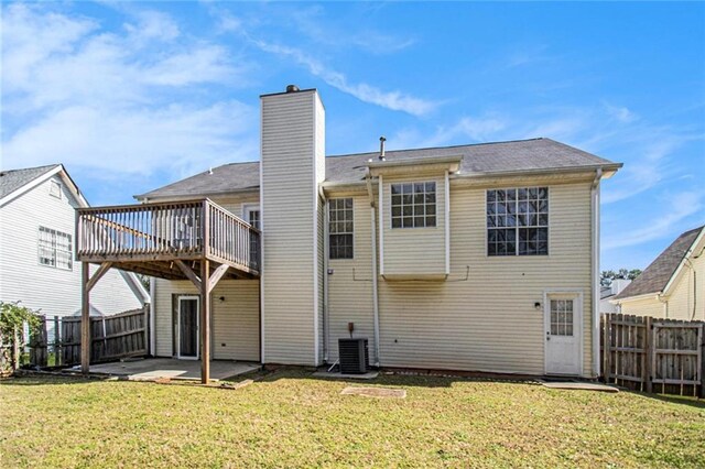 back of property featuring a fenced backyard, a lawn, a chimney, and a patio
