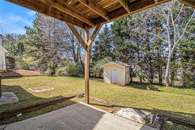 view of yard with an outbuilding, a storage unit, a patio, and fence