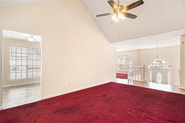carpeted empty room with ceiling fan with notable chandelier, a textured ceiling, high vaulted ceiling, and baseboards