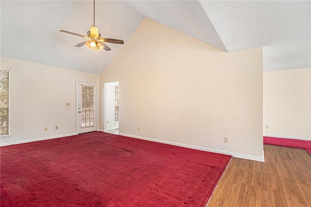 unfurnished room with high vaulted ceiling, wood finished floors, baseboards, and ceiling fan