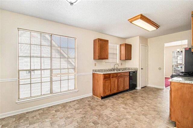 kitchen with baseboards, brown cabinets, black dishwasher, and light countertops