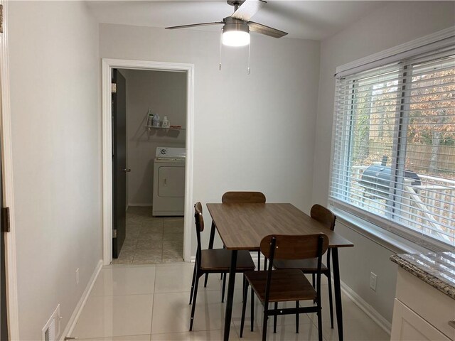 dining room with visible vents, baseboards, ceiling fan, light tile patterned floors, and washer / dryer