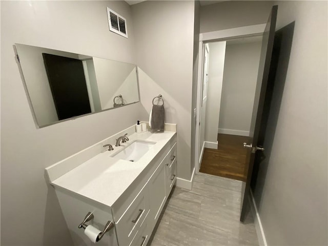 bathroom featuring vanity, baseboards, and visible vents