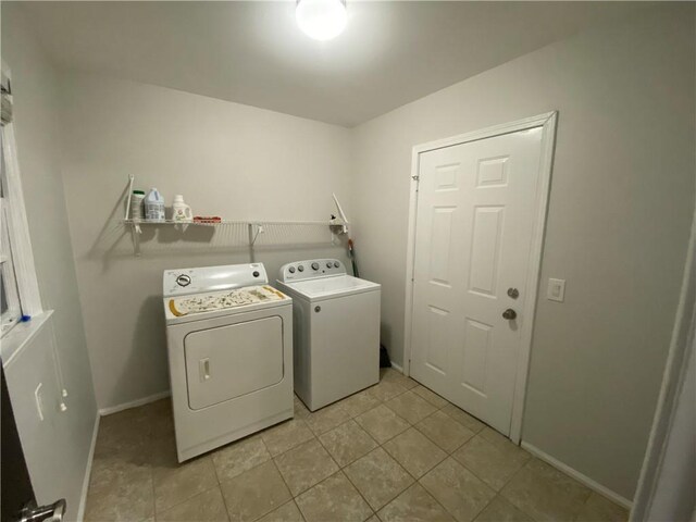 laundry room featuring washer and dryer, baseboards, laundry area, and light tile patterned floors