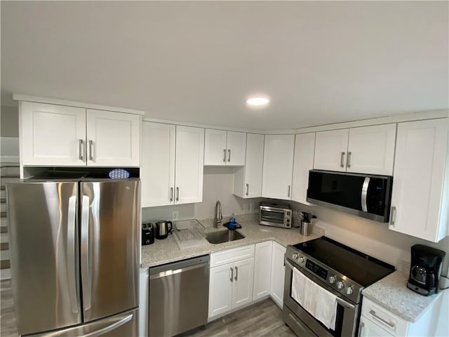 kitchen with white cabinets, appliances with stainless steel finishes, and a sink