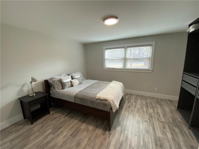 bedroom with baseboards and wood finished floors