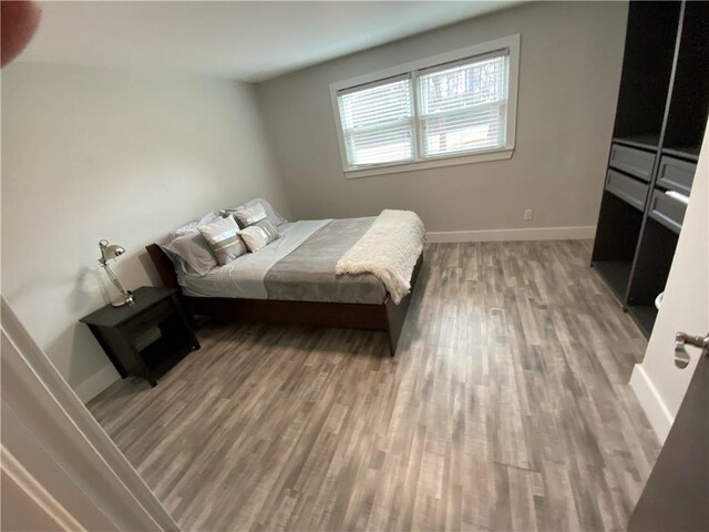 bedroom featuring baseboards and wood finished floors