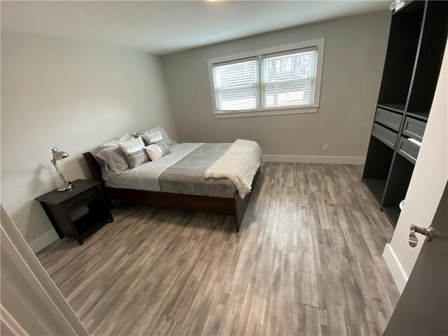 bedroom with wood finished floors and baseboards