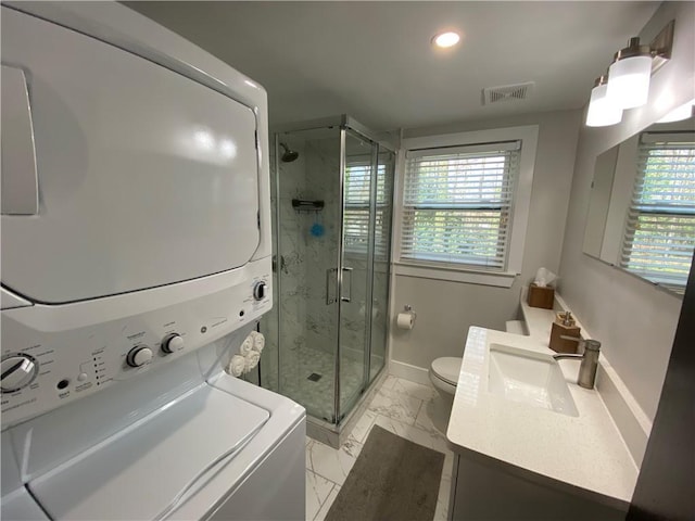bathroom with visible vents, a shower stall, baseboards, stacked washer and dryer, and marble finish floor