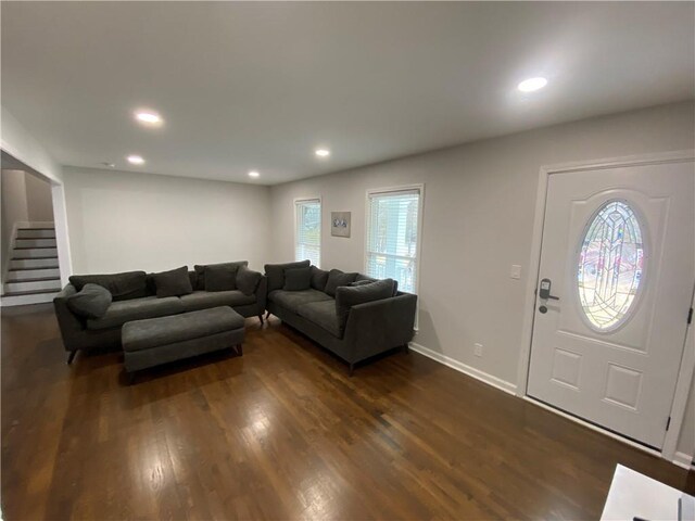 living area with recessed lighting, baseboards, dark wood-style floors, and stairs