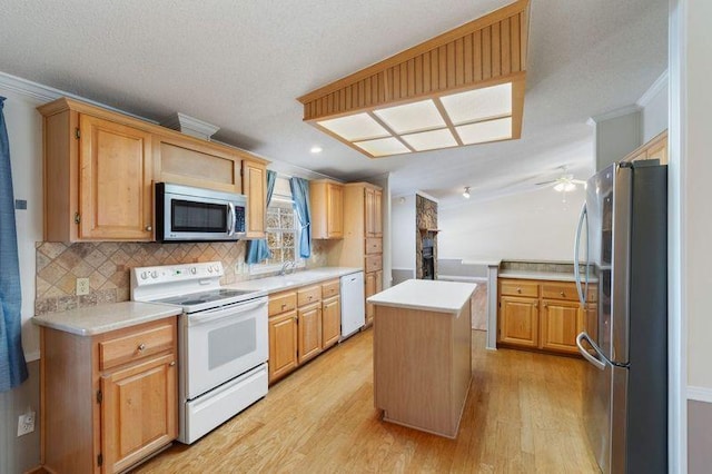 kitchen with a kitchen island, decorative backsplash, ornamental molding, light hardwood / wood-style floors, and stainless steel appliances