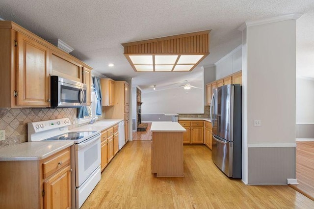 kitchen with a center island, ornamental molding, appliances with stainless steel finishes, light hardwood / wood-style floors, and decorative backsplash