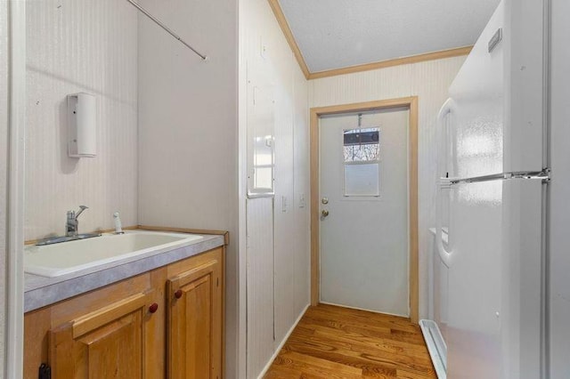 bathroom with crown molding, vanity, and hardwood / wood-style floors