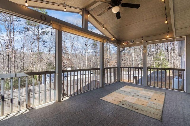 unfurnished sunroom with lofted ceiling with beams, track lighting, and ceiling fan