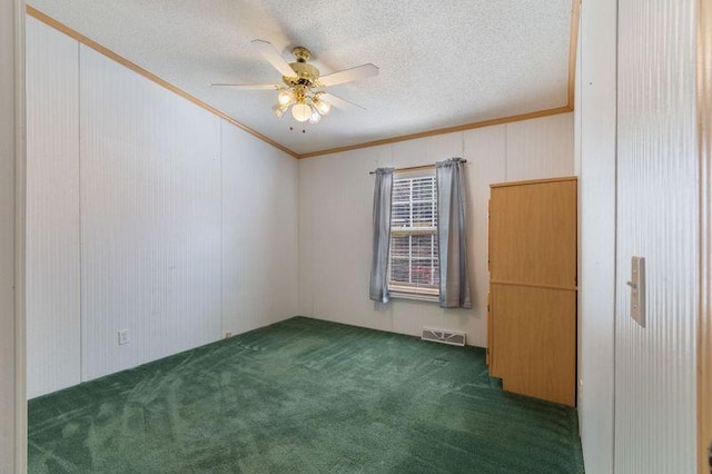 carpeted spare room featuring crown molding, ceiling fan, and a textured ceiling