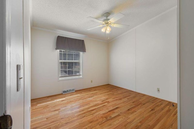 spare room with ceiling fan, ornamental molding, light hardwood / wood-style flooring, and a textured ceiling