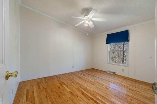 unfurnished room featuring ornamental molding, a textured ceiling, and light hardwood / wood-style floors