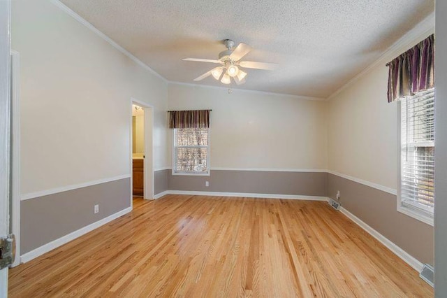 empty room featuring ornamental molding, ceiling fan, a textured ceiling, and light wood-type flooring