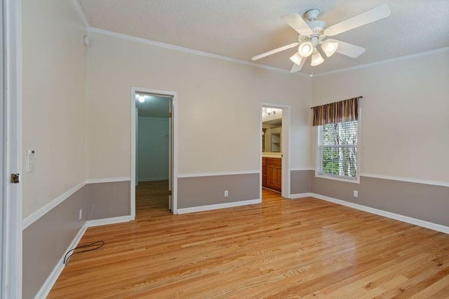 unfurnished bedroom with crown molding, a spacious closet, and light hardwood / wood-style flooring