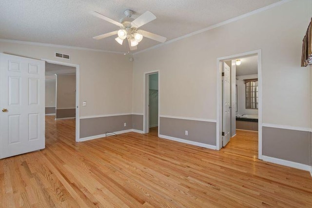 unfurnished room with crown molding, a textured ceiling, ceiling fan, and light wood-type flooring