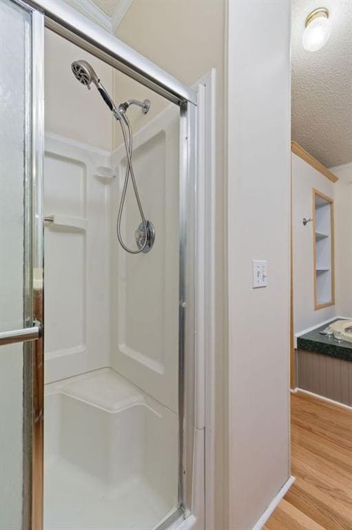 bathroom with vanity, a textured ceiling, a shower with shower door, and wood-type flooring