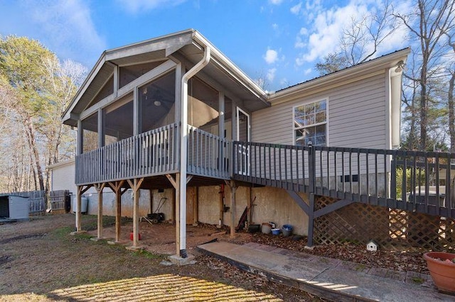 rear view of property with a sunroom and a deck