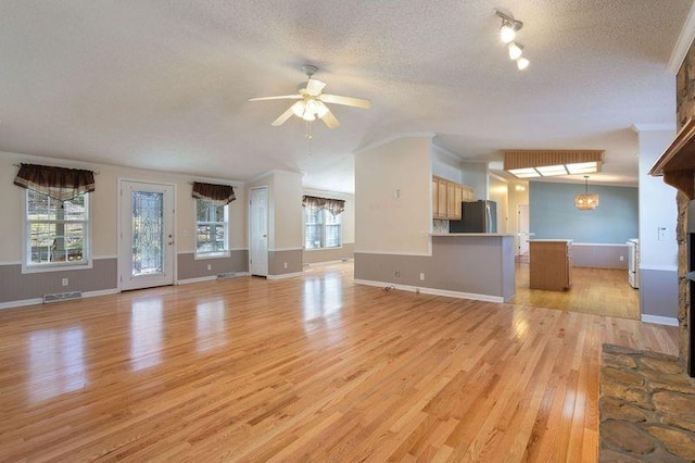 unfurnished living room with a textured ceiling, ceiling fan, and light hardwood / wood-style flooring