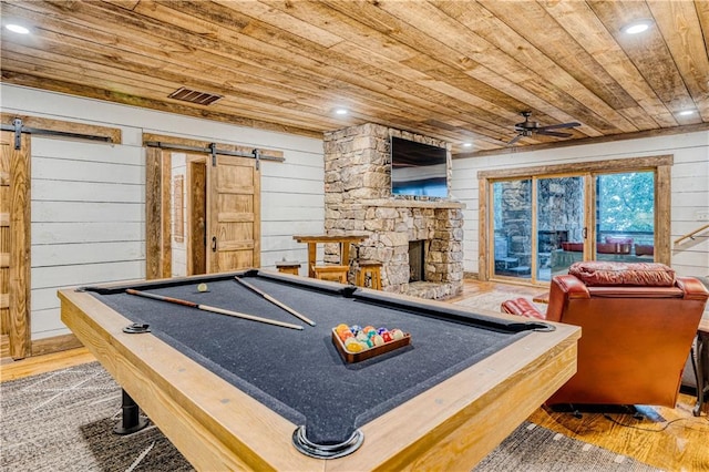 game room featuring wooden ceiling, hardwood / wood-style flooring, and a barn door