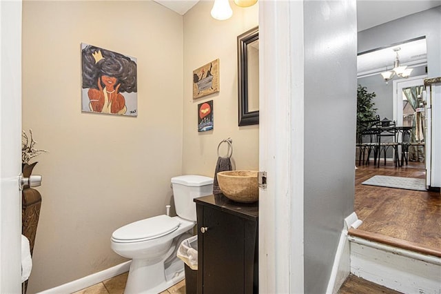 82 Twiggs Cor, Peachtree City, GA 30269 - half bath featuring vanity, toilet, baseboards, a chandelier, and wood finished floors