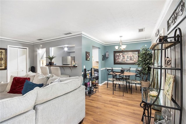 82 Twiggs Cor, Peachtree City, GA 30269 - living room featuring light wood-type flooring, crown molding, a chandelier, baseboards, and a textured ceiling