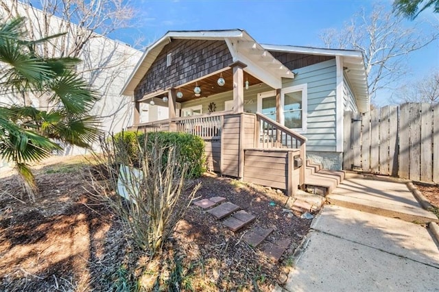 view of front of property featuring fence and a porch