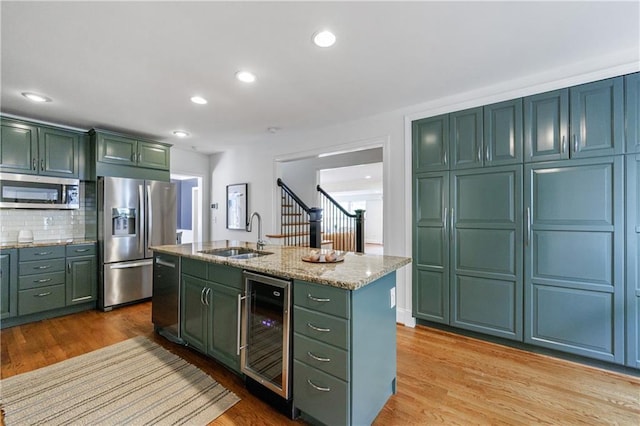 kitchen with appliances with stainless steel finishes, green cabinetry, and wine cooler