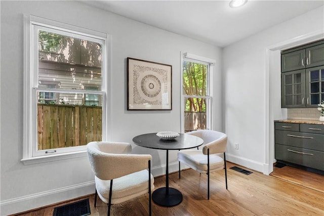 dining room with visible vents, light wood-style flooring, and baseboards