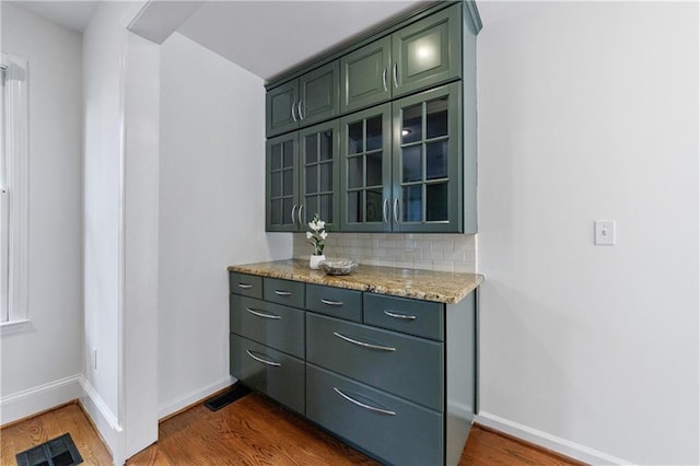 bar featuring baseboards, visible vents, dark wood-style flooring, and decorative backsplash