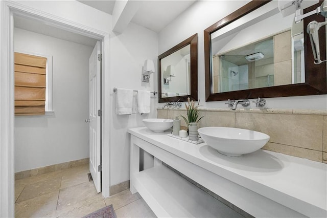 full bathroom with walk in shower, double vanity, a sink, and baseboards