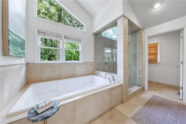 bathroom featuring a garden tub, a stall shower, tile patterned flooring, and lofted ceiling