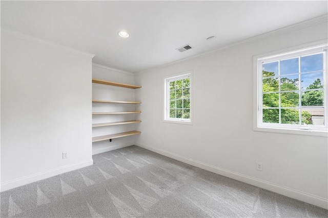 unfurnished room with visible vents, plenty of natural light, and ornamental molding