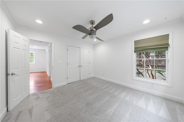 unfurnished bedroom featuring recessed lighting, a closet, crown molding, carpet, and baseboards
