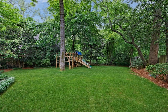 view of yard with a playground and fence